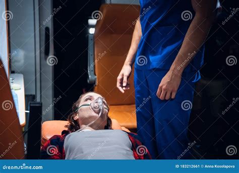 A Woman Lying On A Stretcher With An Oxigen Mask On And Looking At The