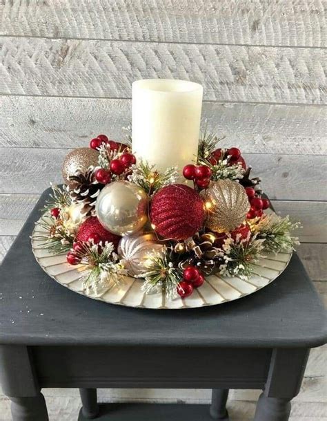 A Candle Sits On Top Of A Plate With Christmas Decorations And Baubles