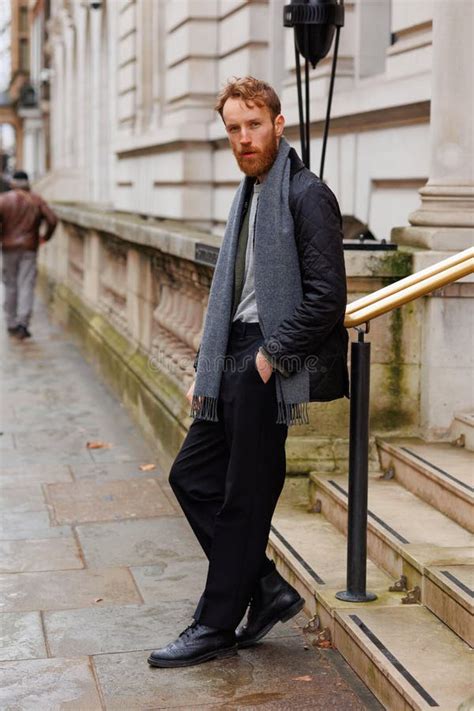 Bearded Hipster Leans Against A Railing In The Middle Of A London