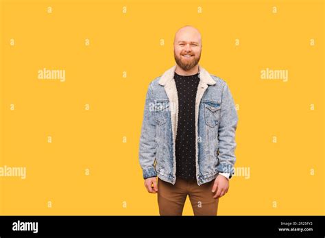 Studio Portrait Of A Wide Smiling Bald Bearded Man Wearing Jeans Jacket