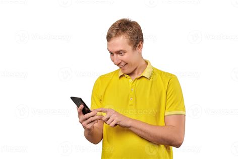 Surprised young man with smartphone, funny guy holding phone isolated on white background ...