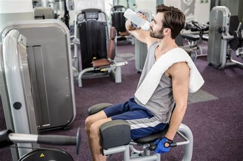 Agua Potable Del Hombre Hermoso En El Gimnasio Foto Premium