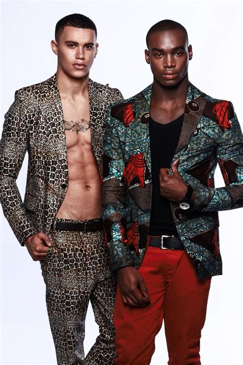 Two Men Standing Next To Each Other In Matching Outfits