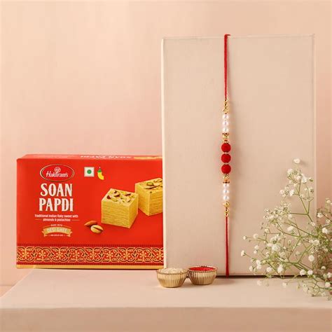 Send White Pearl And Velvet Beads Rakhi With Grams Soan Papdi