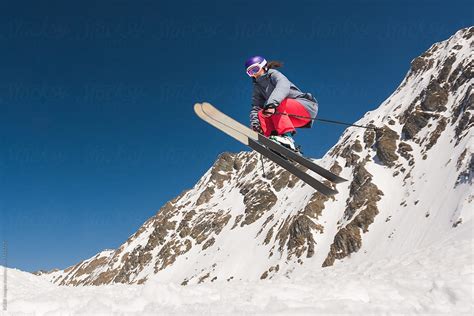 "Woman On Skis Jumping In Midair Off Snow-capped Cliff" by Stocksy Contributor "Ibex.media ...