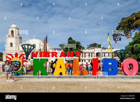 Visitors Pose In Front Of A Vibrant Kalibo Sign During The Ati-Atihan ...