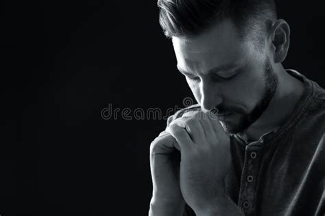 Man With Hands Clasped Together For Prayer On Dark Background Black