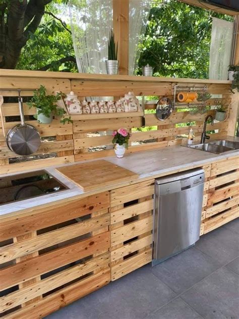 An Outdoor Kitchen Made Out Of Pallets And Wooden Planks With