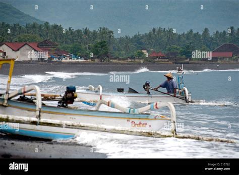 A Balinese Fisherman In A Traditional Outrigger Called A Jukung Returns