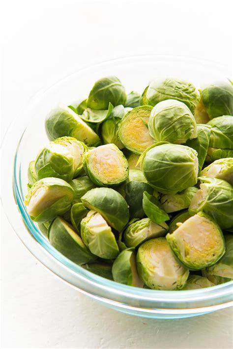 Washed And Halved Brussels Sprouts In A Glass Bowl On A White Table Top Roasted Brussel