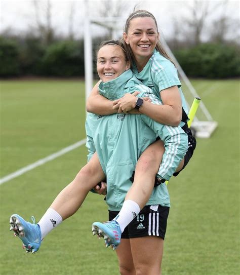 two girls are hugging each other on the soccer field