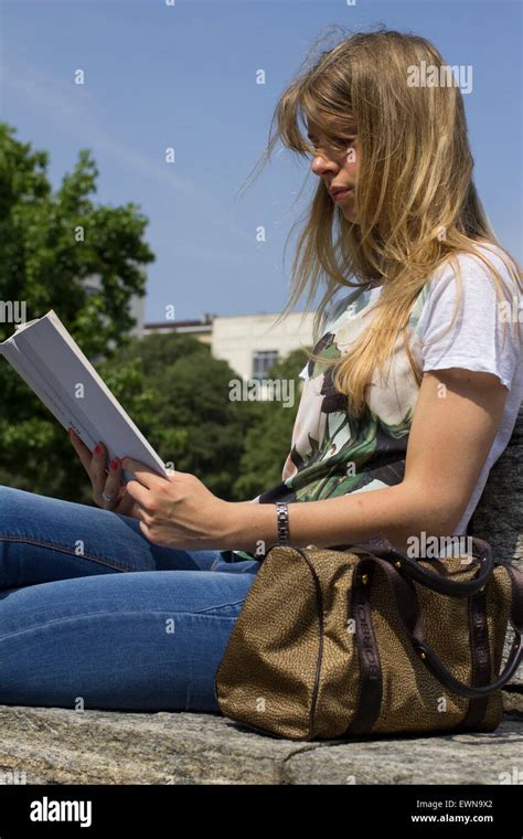 Portrait Of A Female Blonde Student Reading A Book Outside In The City Stock Photo Alamy