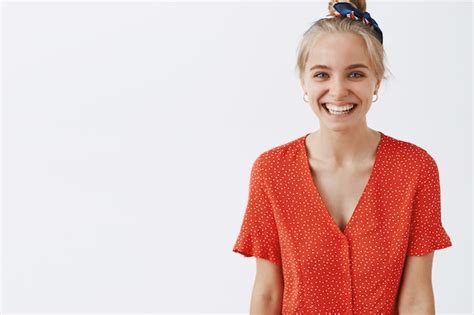 Enthousiaste Jeune Fille Blonde Posant Contre Le Mur Blanc Photo Gratuite