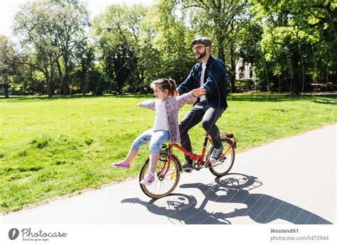 Glücklicher Vater fährt Fahrrad mit Tochter in einem Park ein