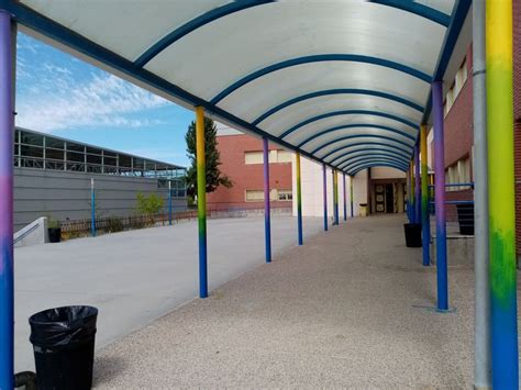 An Empty Walkway With Blue Yellow And Purple Poles On Both Sides Is