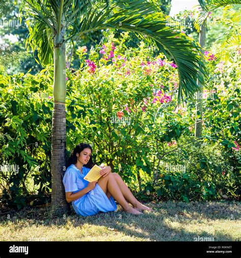 Jeune Femme Assise Dans Un Jardin Tropical Et La Lecture Dun Livre La