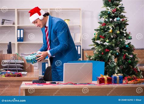 Young Male Employee Celebrating Christmas At Workplace Stock Photo