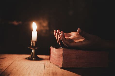 photo close  mans hand  praying   church  lit candle