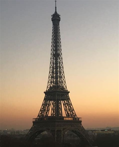 The Eiffel Tower Is Lit Up At Sunset