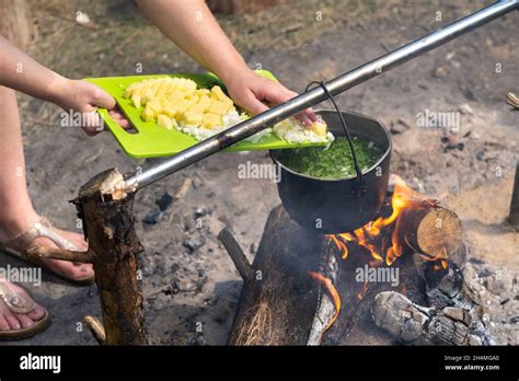 Throw The Ingredients Into The Soup Which Is Cooked Over A Fire In A