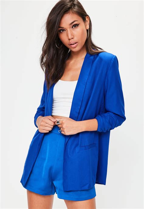 A Cobalt Blue Blazer With A Thin Collar Front Pockets And Gathered