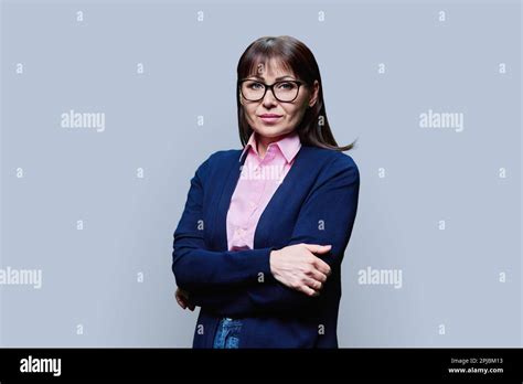 Serious Mature Woman Posing Against Grey Background Stock Photo Alamy