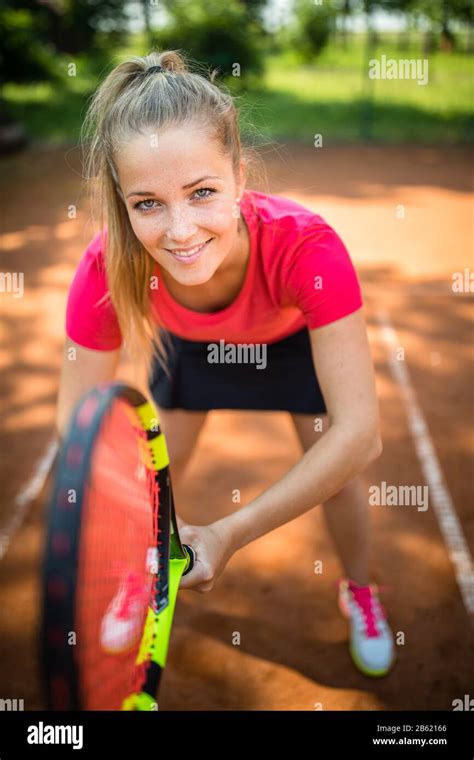 Bonita Joven Mujer Jugador De Tenis Jugando En Una Cancha De Arcilla