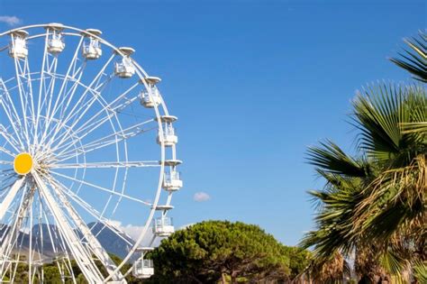 Premium Photo Ferris Wheel In An Amusement Park Against The Blue Sky