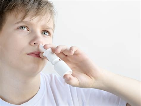 Premium Photo Cold Boy Using Nasal Spray Close Up Copy Space