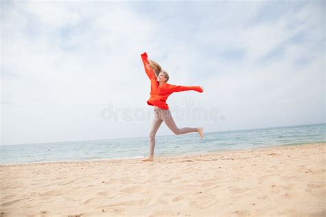 Fille Blonde Sautant Sur Un Bord De Mer De Plage Sablonneuse Image stock Image du liberté