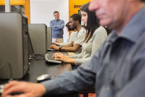 Premium Photo Teacher Standing At Front Of Computer Class