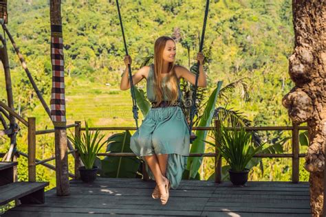 Young Woman Swinging In The Jungle Rainforest Of Bali Island Indonesia