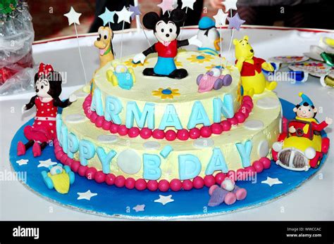 Colorful birthday cake decorated with little cartoon characters on the ...