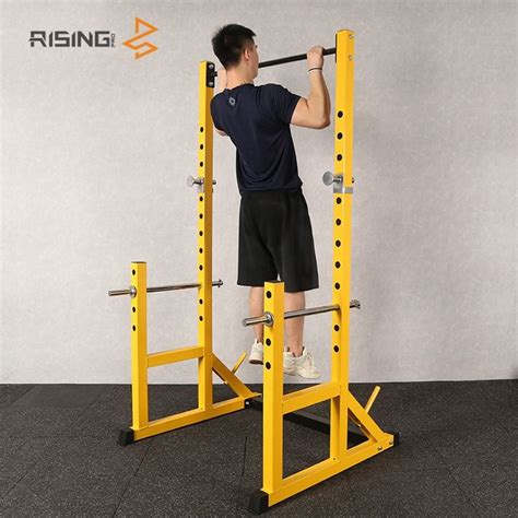 A Man Is Doing Squats On A Yellow Pull Up Bar In The Gym