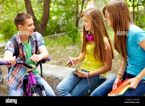 Bicycling Boy Meeting His Female Classmates In Park Stock Photo Alamy