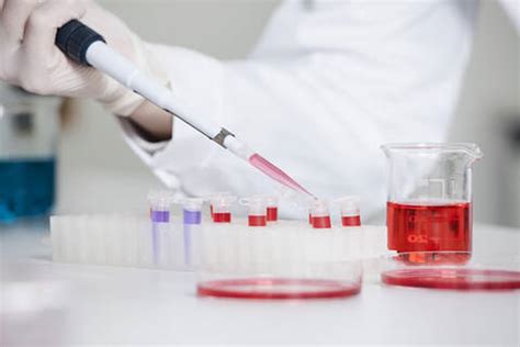 Germany Bavaria Munich Scientist Pouring Red Liquid In Test Tube For