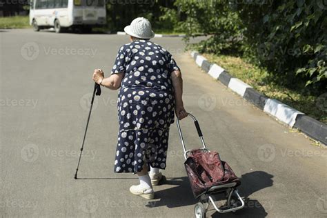 Old Woman With Walking Stick Pensioner In Russia Woman With Bag Walks