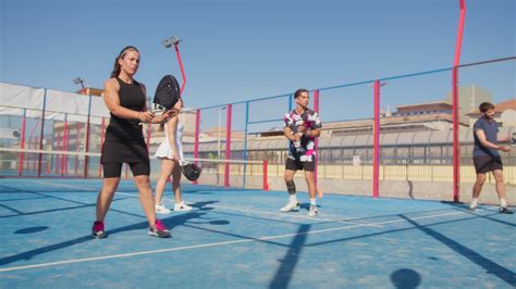 Teacher And Pupils Practicing Shot Against Glass In Padel Court