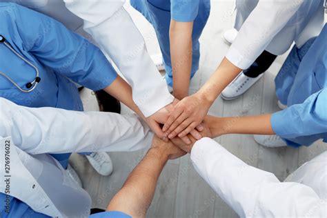 Team Of Medical Workers Holding Hands Together Indoors Top View Unity