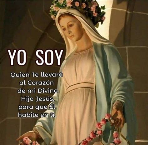 A Statue Of The Virgin Mary Holding Flowers In Her Hands With Spanish