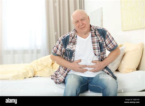 Mature Man Suffering From Pain At Home Stock Photo Alamy