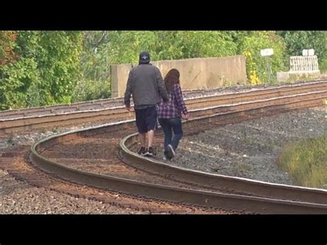 Man And Woman On Train Tracks With Big Train Coming Chasing A Union