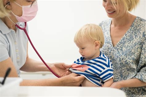 Bebé niño niño siendo examinado por su médico pediatra durante un