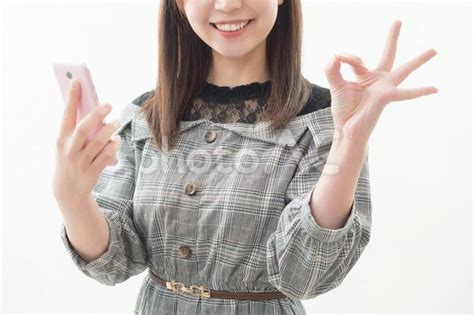 スマホを持ちokサインをする女性 No 2307997｜写真素材なら「写真ac」無料（フリー）ダウンロードok