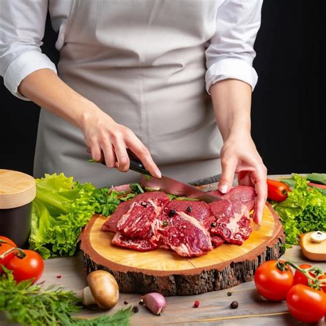 Premium Ai Image Chef Cuts Beef Into Steaks On A Wooden Plank