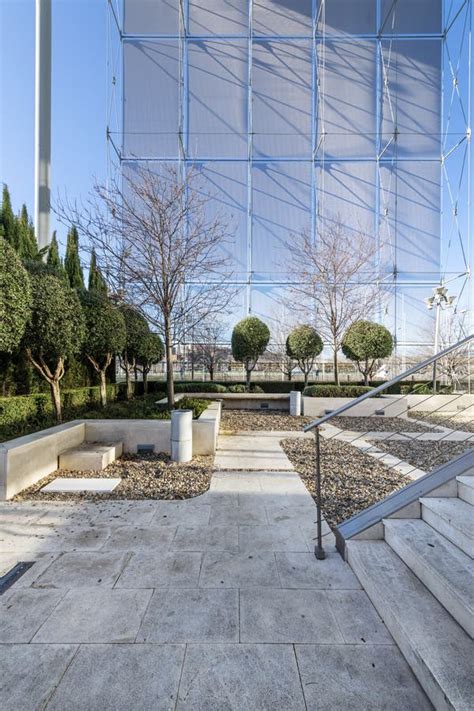 Recreation Area in the Shade of an Office Building with Hedges, Trimmed Trees and White Stone ...