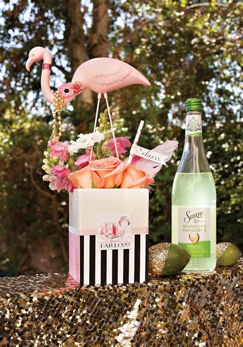 A Pink Flamingo Figurine Sitting On Top Of A Table Next To A Bottle Of Wine