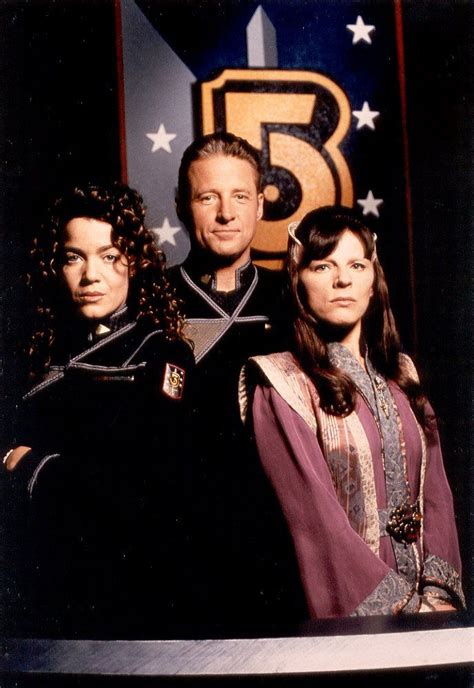 Two Men And A Woman Standing In Front Of A Large Number Three Sign With