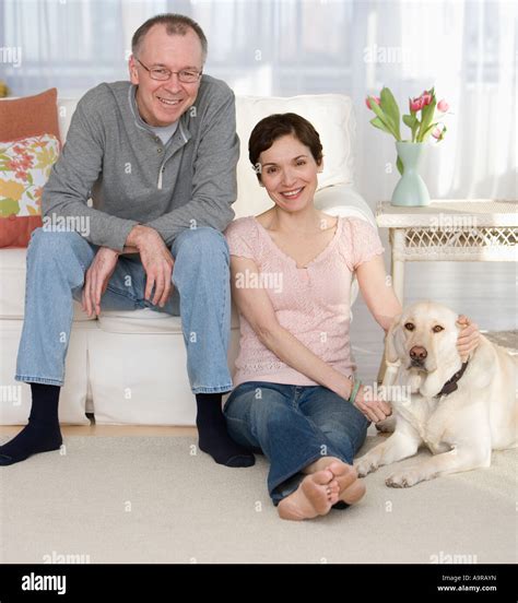 Portrait Of Couple With Dog In Livingroom Stock Photo Alamy