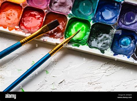 Two paint brushes and a palette with watercolour paints Stock Photo - Alamy